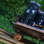 Koffer die auf einer Bahnschiene den Berg hinauf gefahren werden. Konsumkredit abgeschlossen
